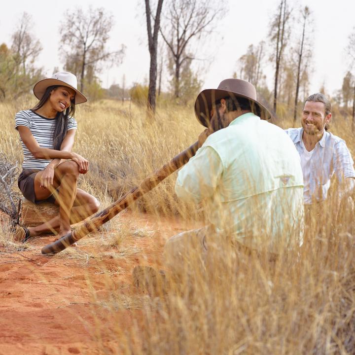 indigenous man playing the didgeridoo