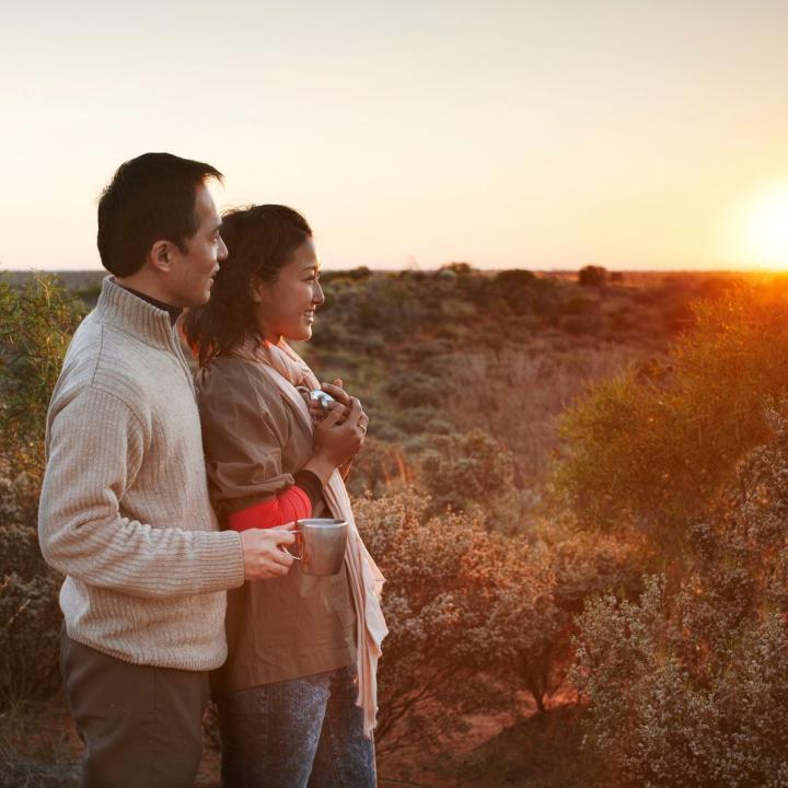 couple enjoy coffee on the outback at sunrise