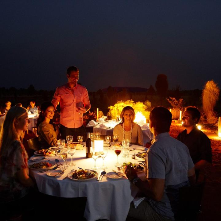 A group of friends enjoying dinner around a table at the Sounds of Silence experience.